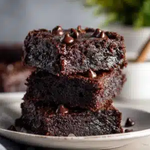 A piece of sugar free black bean brownie being lifted from the plate, showing a gooey chocolate center