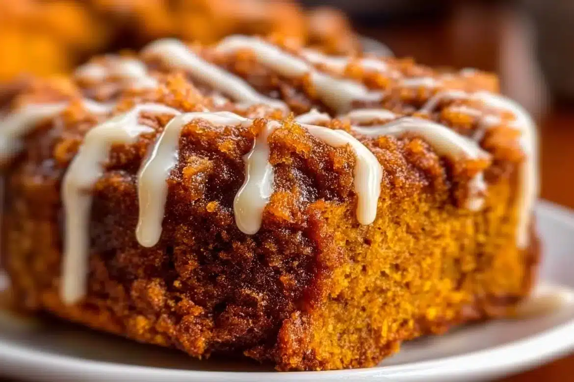 Delicious slice of pumpkin coffee cake topped with icing on a plate
