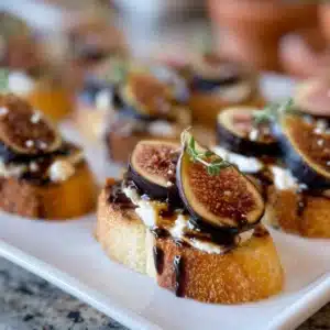 Balsamic oven fig crostinis topped with creamy cheese and fresh herbs