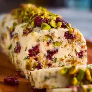 Cranberry Pistachio Cheese Log served on a platter with fresh herbs