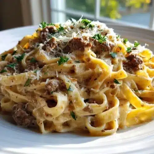 Creamy beef pasta dish garnished with herbs and served in a bowl