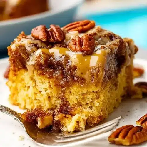 Slice of easy pecan pie dump cake topped with whipped cream