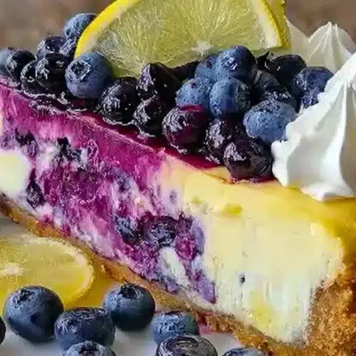 Slice of lemon blueberry cheesecake topped with fresh blueberries.
