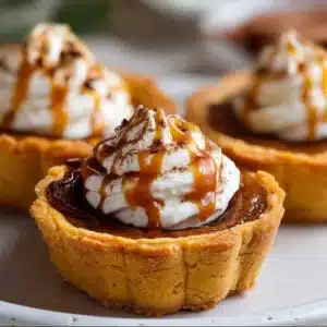 Mini pumpkin pies served on a rustic wooden table.